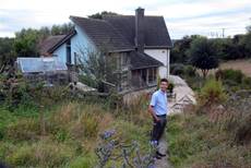 A person standing in front of a house  Description automatically generated with medium confidence